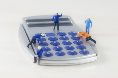 Mini technicians repairing a calculatorの写真素材