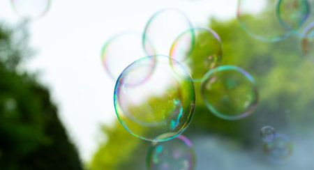 Colorful soap bubbles flying in the air. Blurred background.