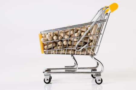 Full shopping cart of medicine, pharmaceutical capsules on whiteの写真素材
