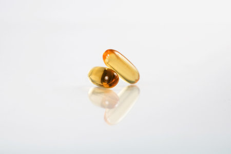 Close up two omega-3 capsules isolated on white background with reflection. Fish Oil.の写真素材