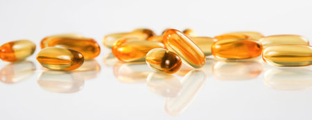 Two capsules Omega 3 isolated on white background and many other of capsules on blurred background....