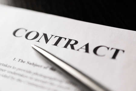 Close-up of word contract with silver ballpoint pen. Selective focus.の写真素材