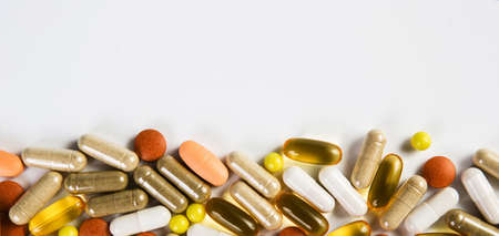 Heap of medicine colored pills, tablets and capsules on a white background. Medicine concept.