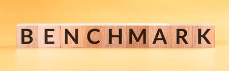 Benchmark text on a wooden cubes on yellow background.の写真素材