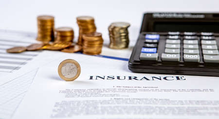 Close up of a calculator and coins on a business background.の写真素材