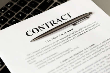 Ballpoint pen for signing the contract. The pen and contract are on the laptop.の写真素材
