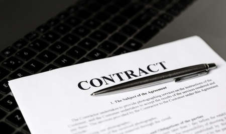 Ballpoint pen for signing the contract. The pen and contract are on the laptop.の写真素材