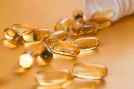 Many capsules Omega 3 on yellow background. Close up, high resolution product. Health care concept.の写真素材