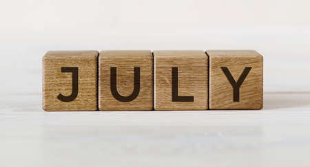 The word July on wooden cubes on light background. Concept Month of year.の写真素材