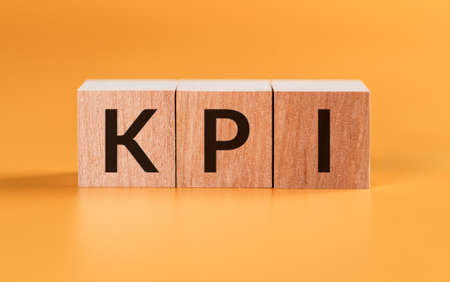 KPI Word Written In Wooden Blocks on Yellow Background. Key Performance Indicator.の写真素材