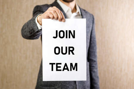 JOIN OUR TEAM, message on letter shown by a businessmanin gray blazer.の写真素材