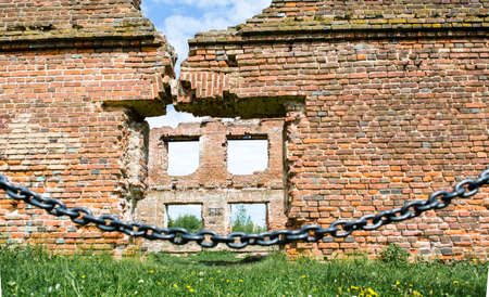 Fence in front of the destroyed wall, ruins of an old mill. The concept of conservation of attractions.の写真素材