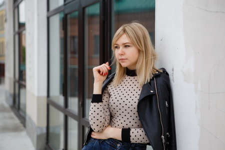 Outdoors lifestyle portrait of happy stunning blonde girl. Walking to the city street.の写真素材