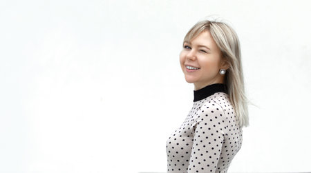Outdoors lifestyle portrait of happy stunning blonde girl. Walking to the city street.の写真素材