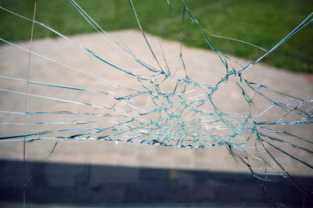 Broken glass or window on the street against the background of the cityの写真素材