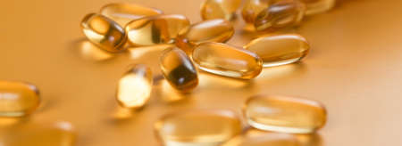 Many capsules Omega 3 on yellow background. Close up, high resolution product. Health care concept.の写真素材