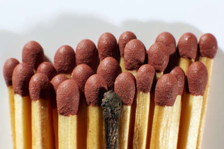 Burnout syndrome, stress, exhaustion and work-life balance concept. Close-up of a single burnt match in a group of matches.の写真素材