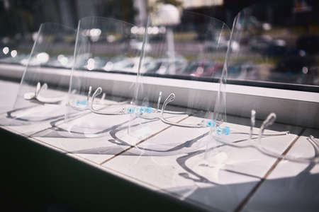 Face Shields are prepared on the white windowsill. It's ready to use. A number face shields, completed assembly with transparent plastic.の写真素材