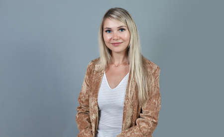 Pretty smiling joyfully female with fair hair, dressed casually, looking at the camera, being happy. Studio shot of beautiful woman isolated against blank studio wall.の写真素材