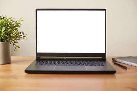 Laptop with blank screen on work wooden table. Front view.の写真素材