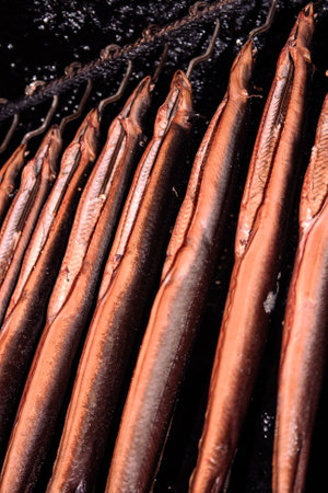 Smoked fish on a black background. Selective focus. Toned.
