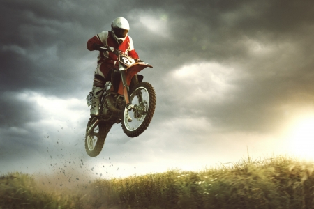 A picture of a biker making a stunt and jumps in the air A picture of a biker making a stunt and jumps in the air