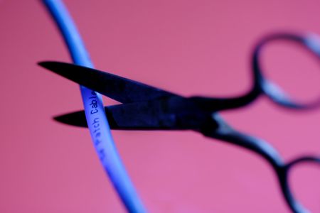 Sissors cutting a blue cableの写真素材