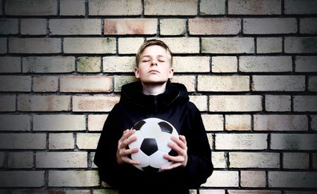 A boy against a wall with a ball の写真素材