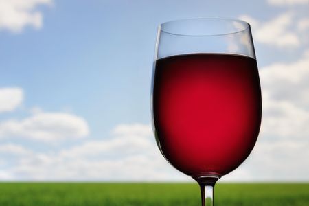 Wine glass outdoors , green field in the backgroundの写真素材