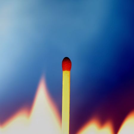 Match surrounded by flame against blue backgroundの写真素材