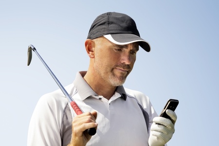 Golfer using mobile phoneの写真素材