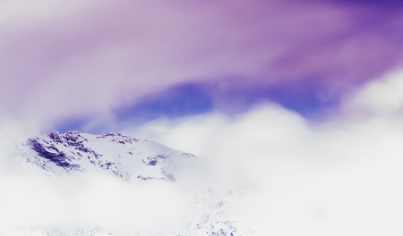 Alpine peak immersed in clouds of stormの写真素材