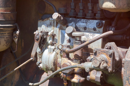 A detailed close-up of a severely rusted and grimy vintage diesel engine's fuel pump and various mechanical components, showing the wear and tear of time and industrial use.の写真素材