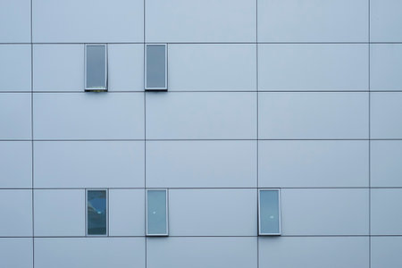 Abstract view of a contemporary building facade featuring a grid pattern and minimalist windows.の写真素材