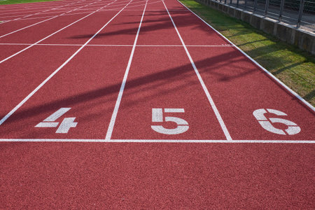 Perspective view of lanes 4 to 6 on a red running track, representing competition, preparation, and athletic determination in a professional sports facility.の写真素材