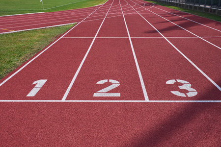Wide view of lanes 1 to 3 on a red athletics track, symbolizing competition, progress, and the...