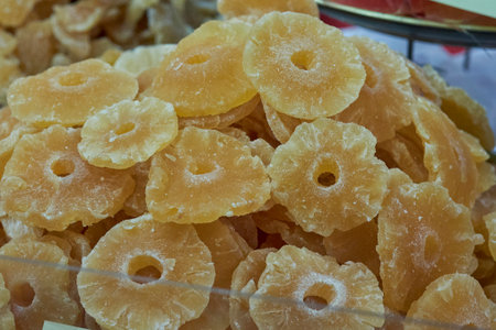 Macro shot of sweet dried pineapple slices stacked together. A tropical and nutritious snack option, perfect for healthy eating, recipes, or on-the-go treats.の写真素材