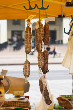 Hanging Italian cured salami at a local market stall, showcasing authentic traditional food and Italian culinary cultureの写真素材