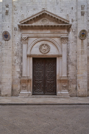 Old church entrance with detailed stone arch and carved wooden doors, symbol of history and Italian architectureの写真素材
