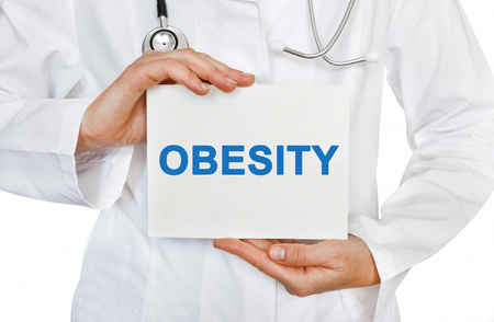 Obesity card in hands of Medical Doctorの写真素材