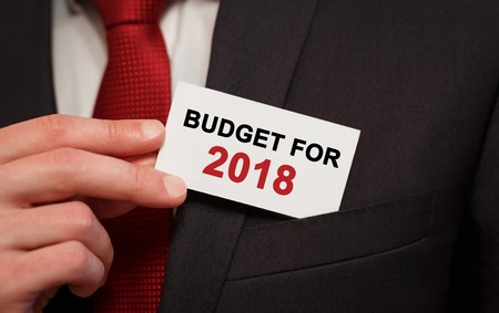 Businessman putting a card with text Budget for 2018 in the pocketの写真素材