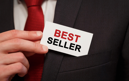Businessman putting a card with text Best Seller in the pocketの写真素材