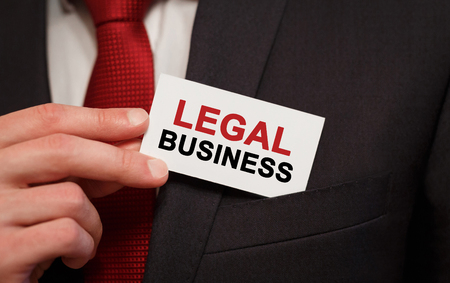 Businessman putting a card with text Legal Business in the pocketの写真素材