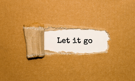 The text Let it go appearing behind torn brown paperの写真素材