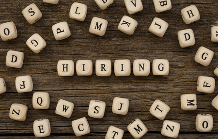 Word HIRING written on wood blockの写真素材