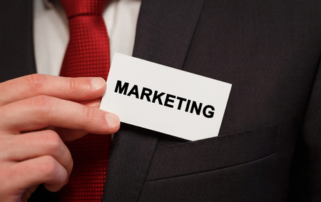Businessman putting a card with text Marketing in the pocketの写真素材
