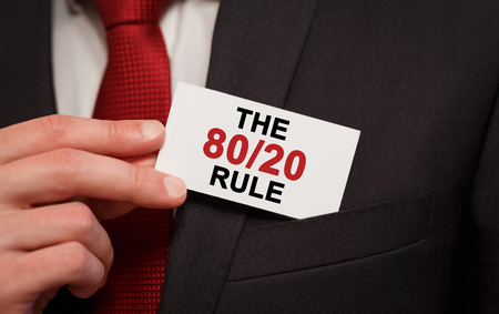 Businessman putting a card with text The 80 on 20 Rule in the pocketの写真素材