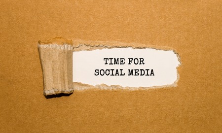 The text TIME FOR SOCIAL MEDIA appearing behind torn brown paperの写真素材