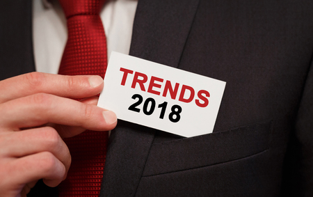 Businessman putting a card with text trends 2018 in the pocketの写真素材