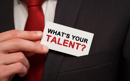 Businessman putting a card with text Whats Your Talent in the pocketの写真素材